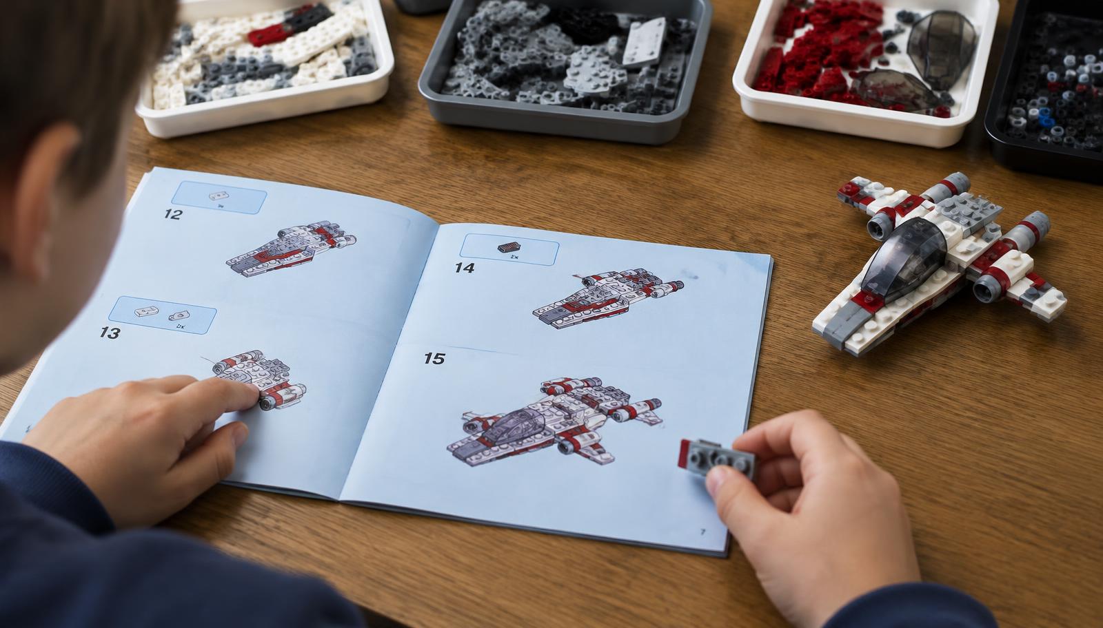 Child following a step-by-step instruction booklet to build a brick spaceship with sorted brick trays