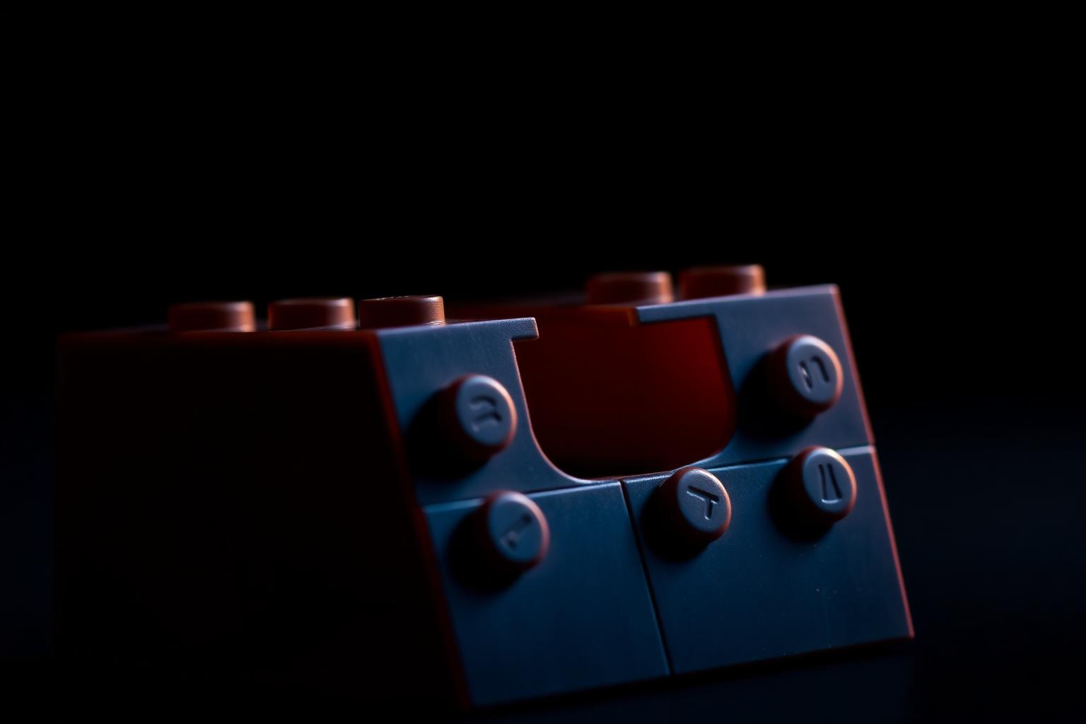 Macro close-up of two plastic building bricks clicking together showing precisely molded studs